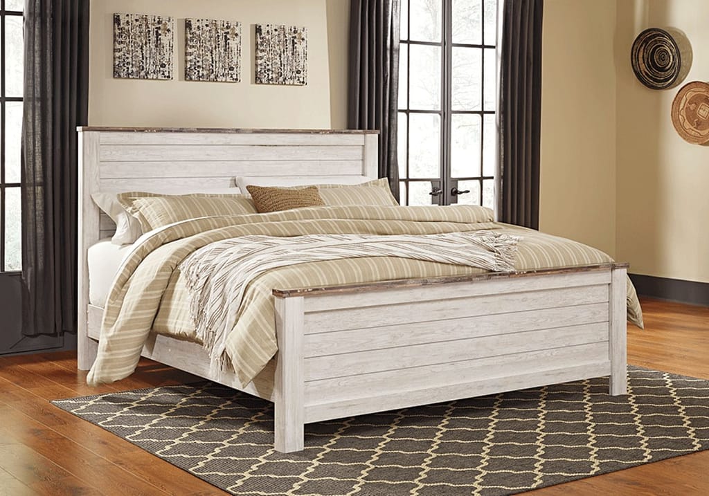White panel bed frame on a dark brown carpet and hardwood floor