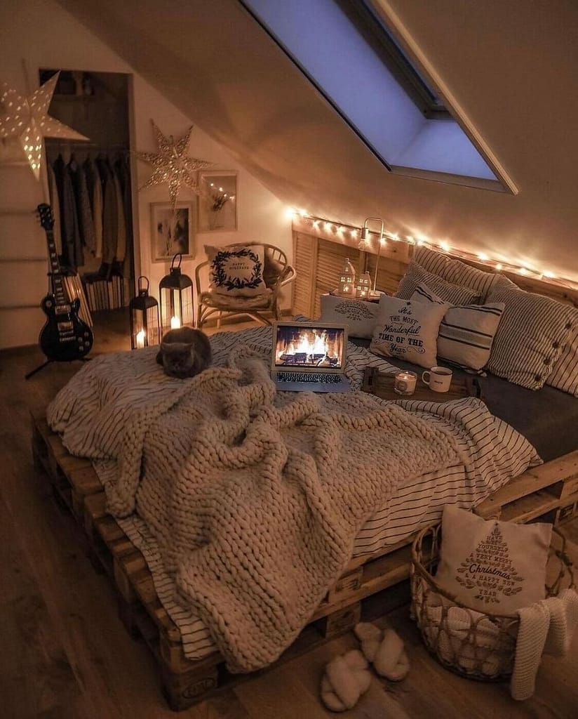Small bedroom with dim lighting and slanted walls and ceiling for coziness