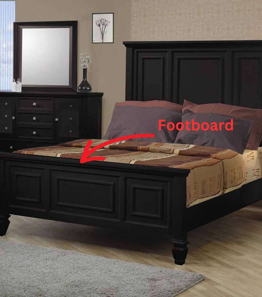 Black bed in a bedroom with a red arrow labeling the footboard of the bed