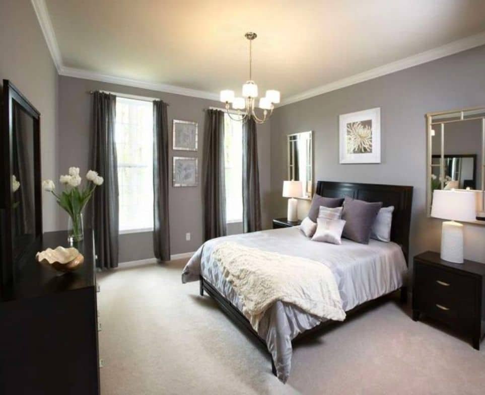 Black bed frame, dresser, and bedside table with light gray bedroom walls
