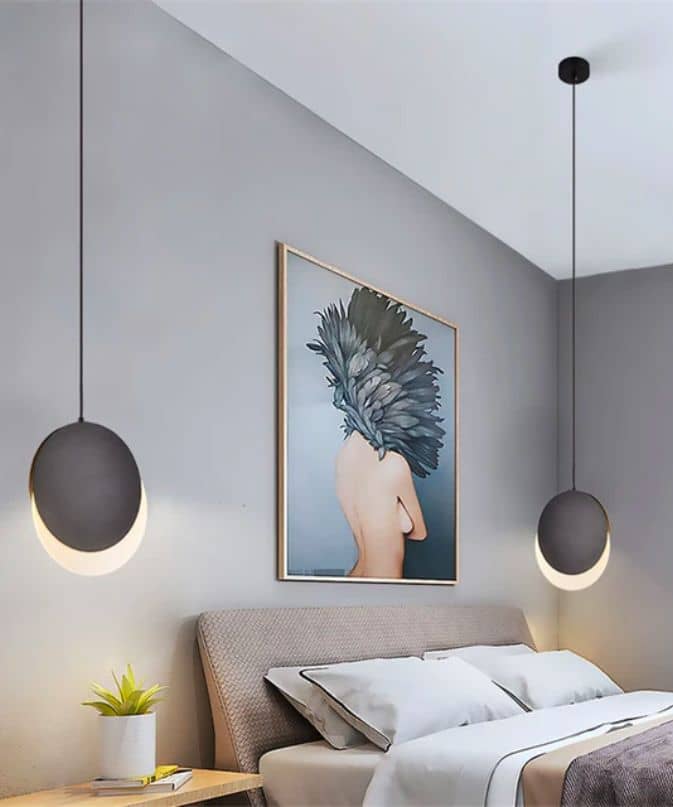 Modern pendant lights next to bed with gray walls