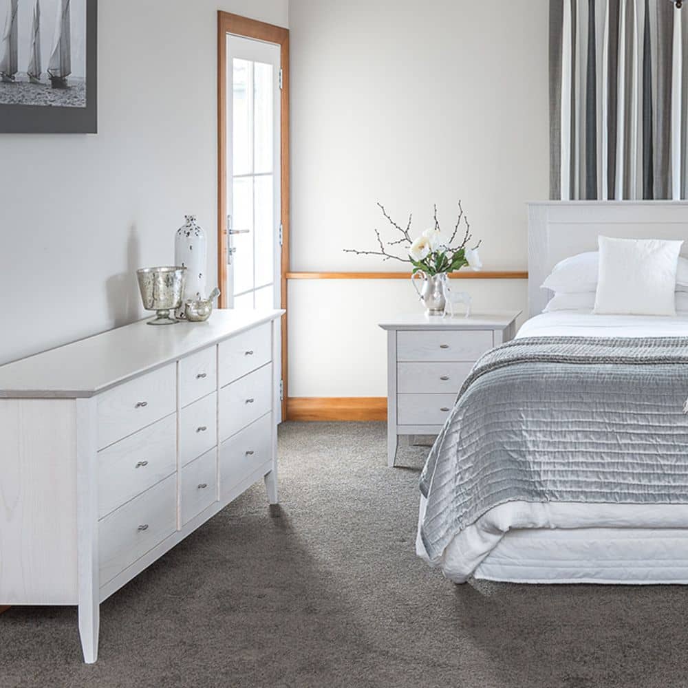 One of the types of furniture in this bedroom is a white lowboy dresser