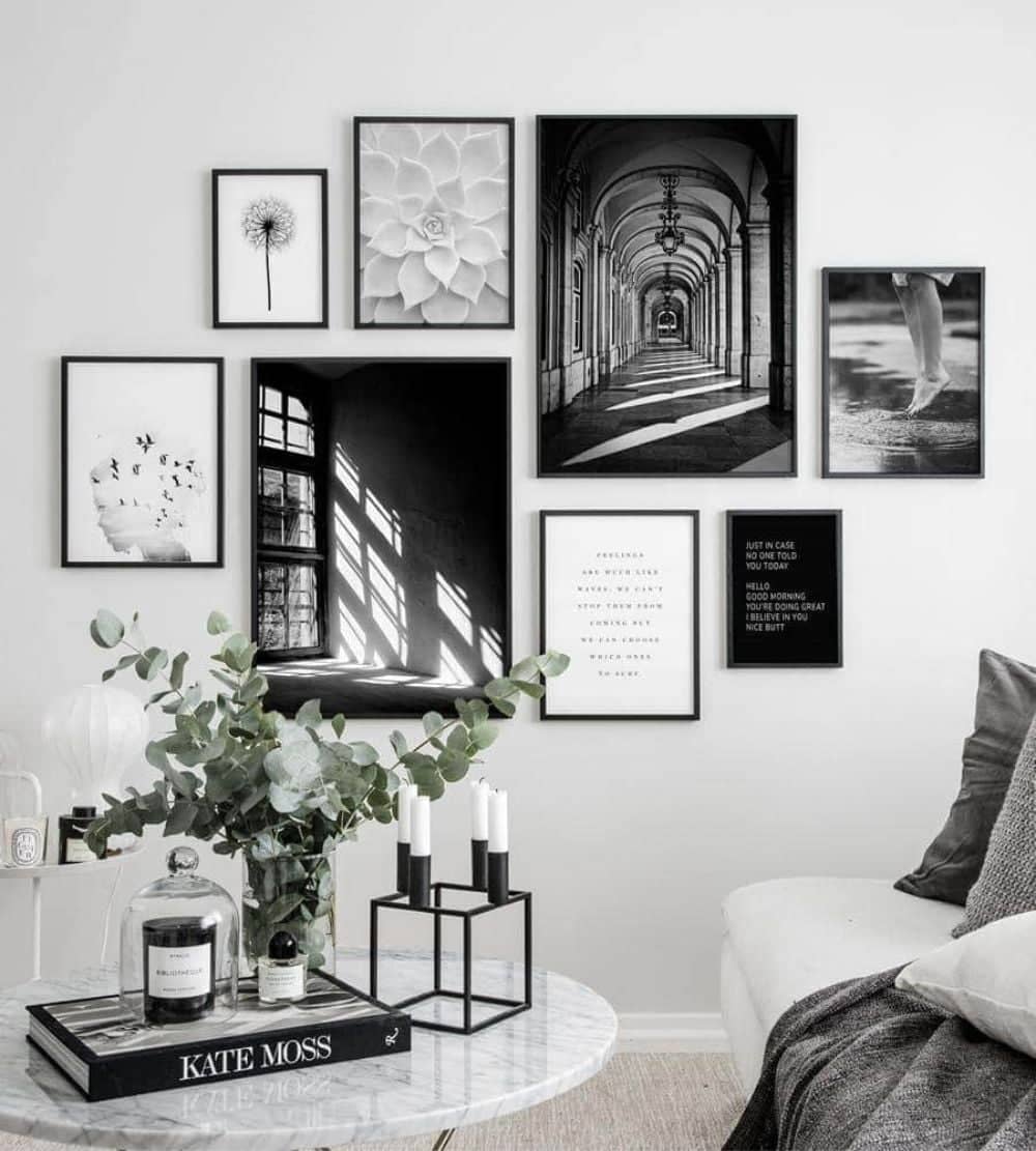 Black and white medium-sized gallery wall with a small table and plant in the front