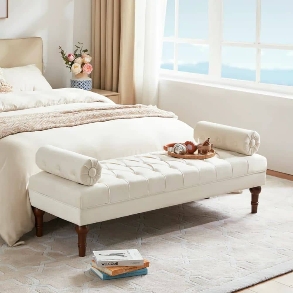 White bench furniture with 2 pillows at the foot of a bed in a white bedroom 