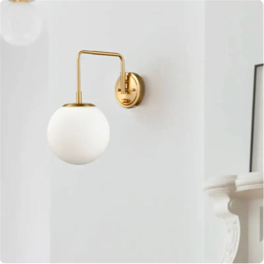 White and gold wall sconce on a white wall